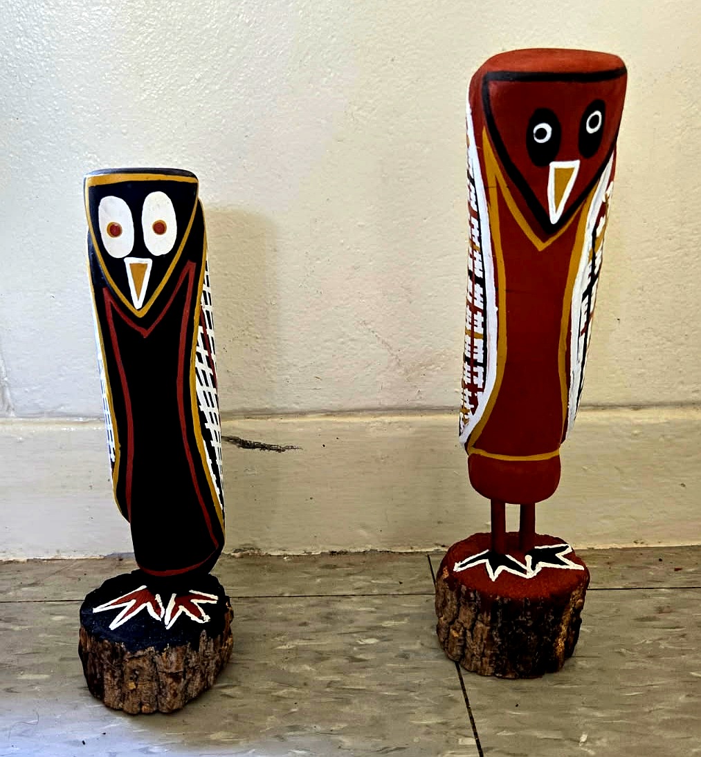 Two carved Yolŋu owl sculptures painted with ochre and rarrk patterns